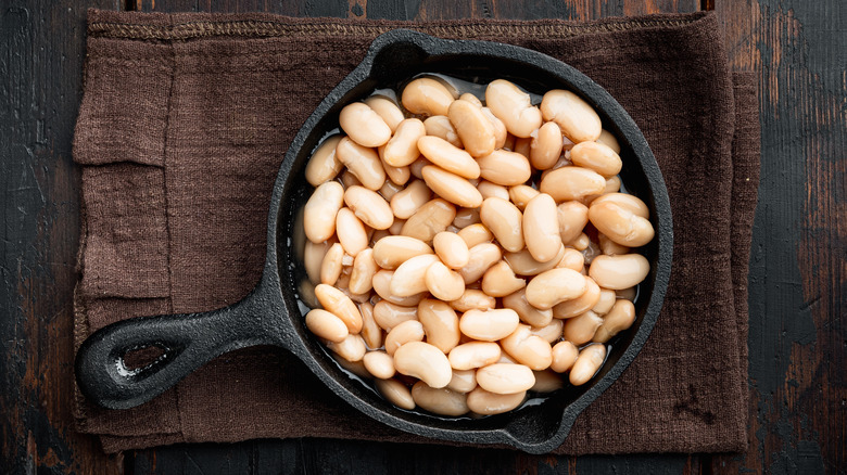 Top view of white beans in a cast iron