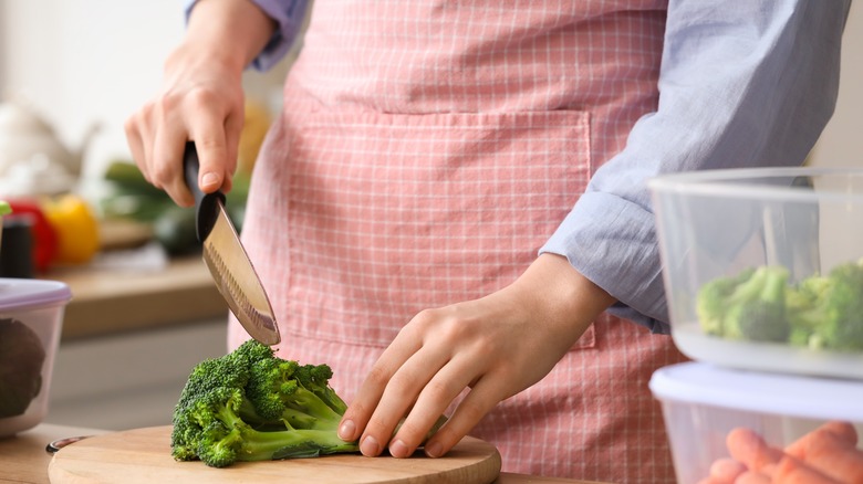 Hands cutting up broccoli