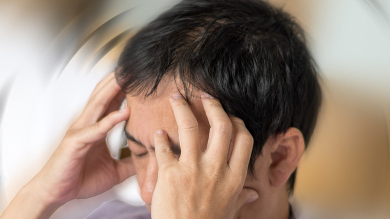 Man holding head/blurry view