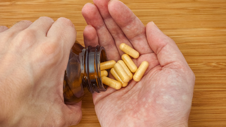 Person shaking B vitamins into hand