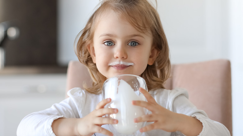 young girl drinking milk with vitamin D