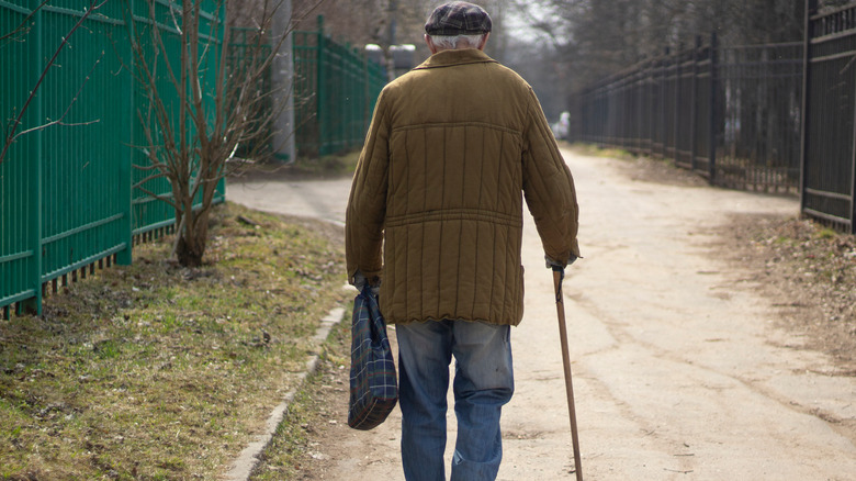 elderly man walking with cane