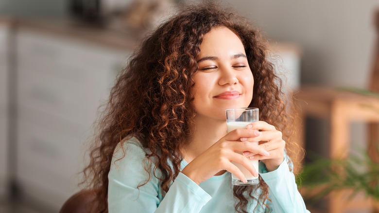 young biracial woman drinking milk