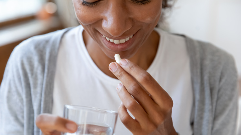 woman happy to take vitamin with water