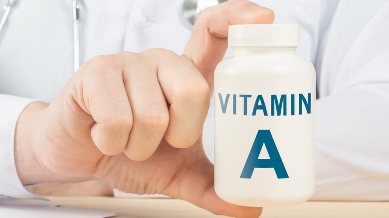 doctor holding vitamin a supplement bottle