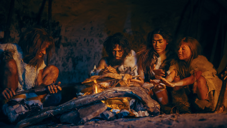 artist rendition of caveman family eating a meal