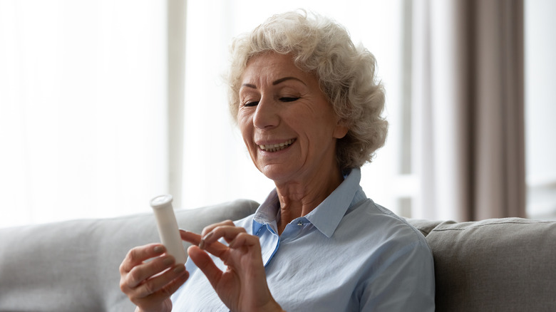 older woman looking at pills