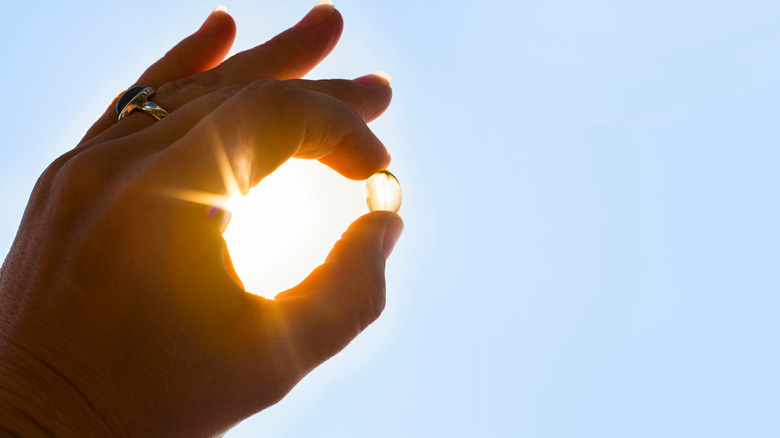 hand holding a vitamin in the sun