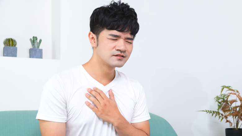 Man in pain with hand on chest