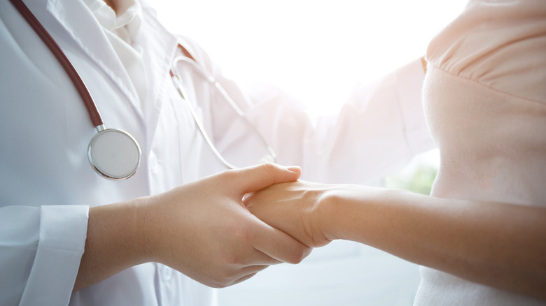 doctor holding hand of patient