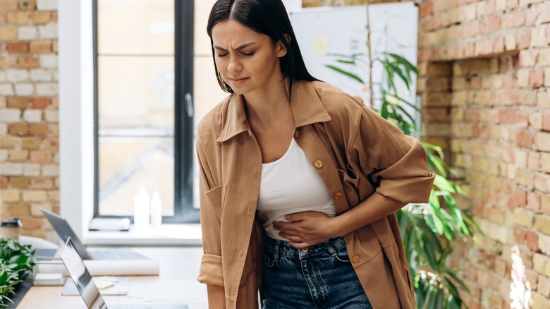 Woman experiencing stomachache indoors