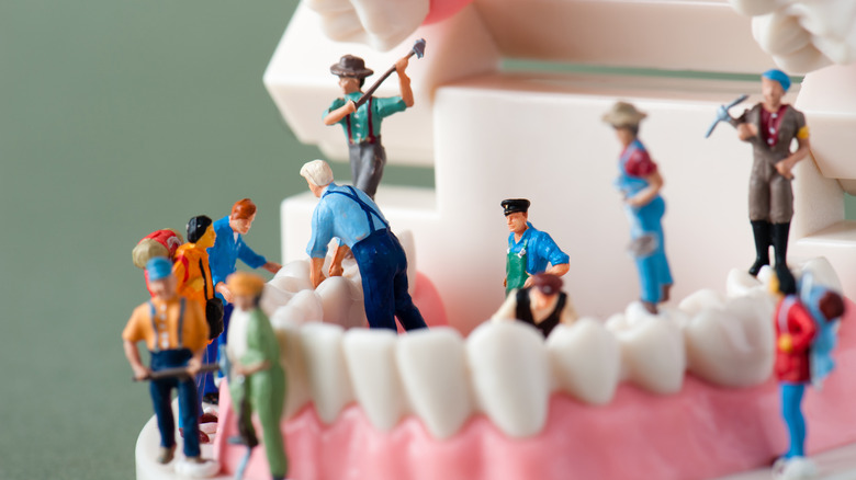 miniature figures cracking fake teeth