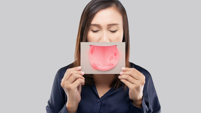 Illustration of woman holding image of geographic tongue.