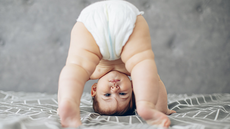 diapered baby standing upside down