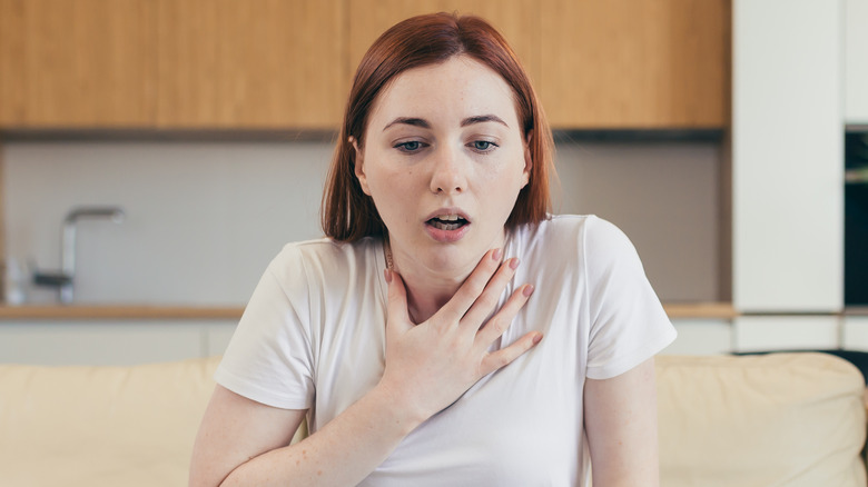 Sitting woman experiencing shortness of breath