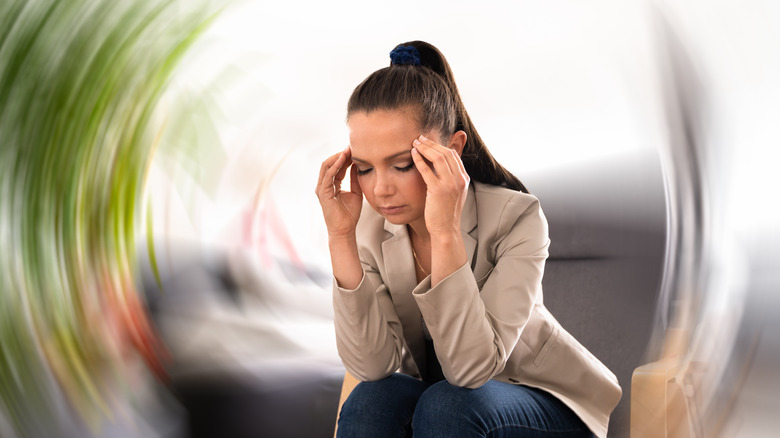 Woman sitting while feeling dizzy