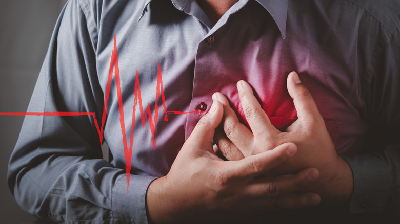 Person holding their heart by EKG reading