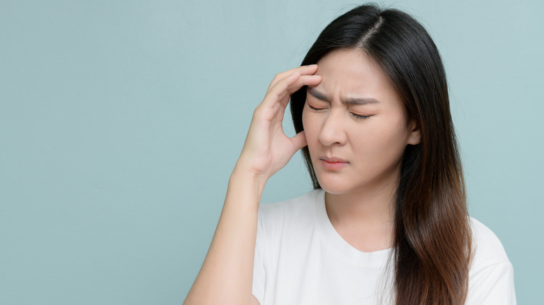 Woman holding her head in pain