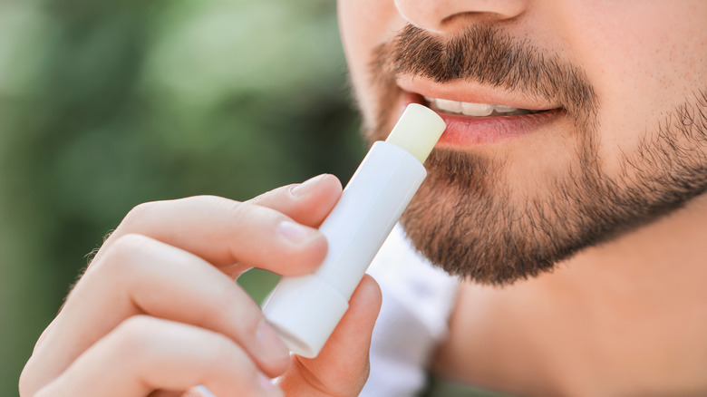 man applying chapstick on lips