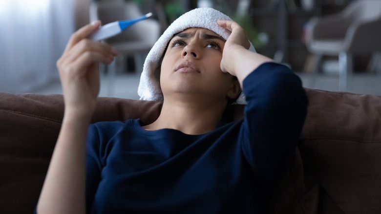 Woman with washcloth on head checking temperature