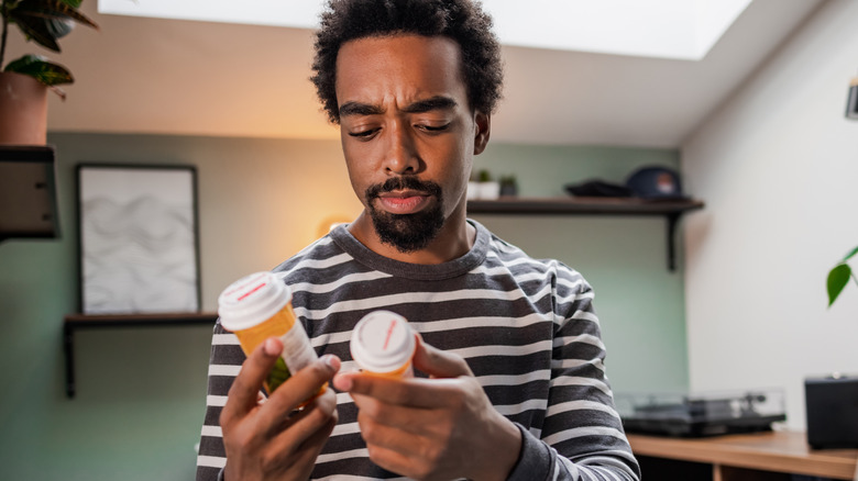 Man examining prescription drug bottles