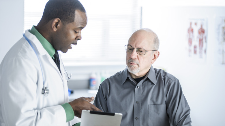 senior man talking with doctor in office