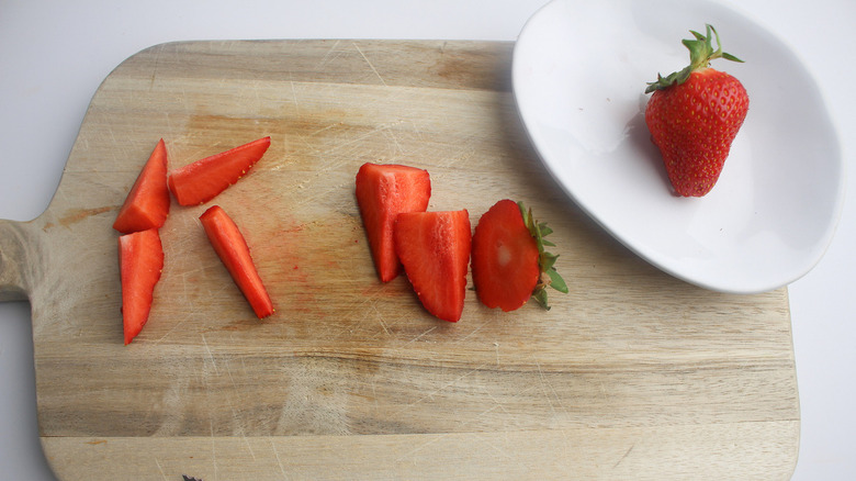 sliced strawberries on cutting board