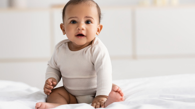 cute baby on white bedsheet