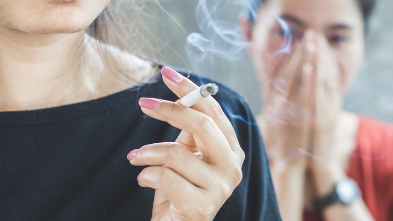 woman holding lit cigarette smoking