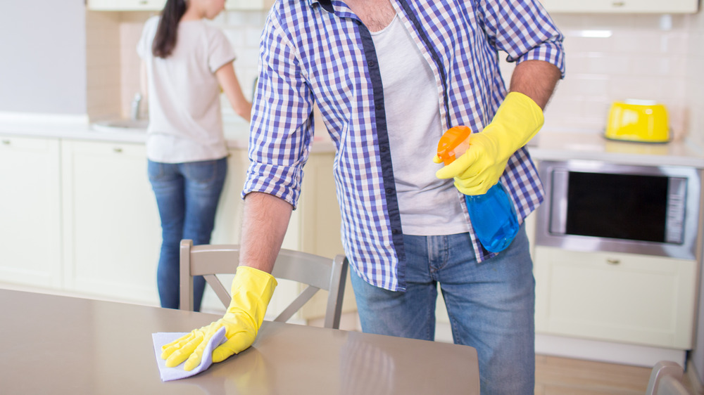 Man wiping down kitchen counter