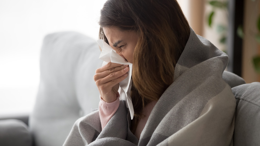 A sick woman blowing her nose