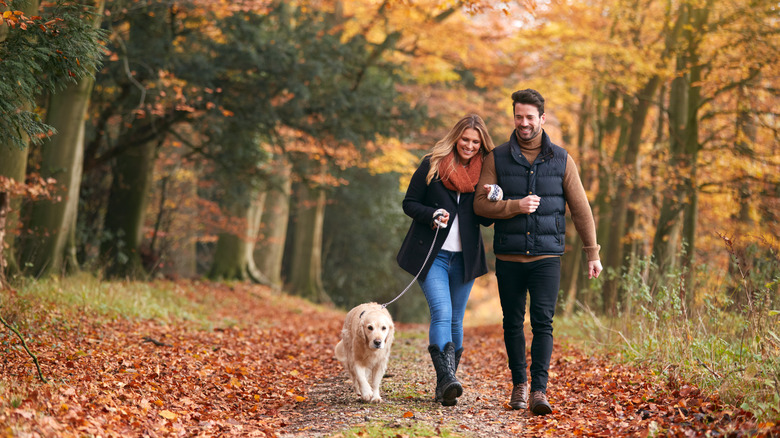 couple and dog on walking path