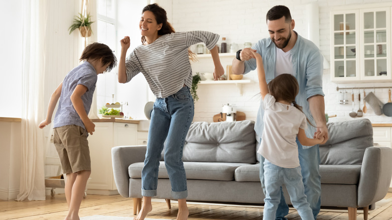 Family dancing happily in living 