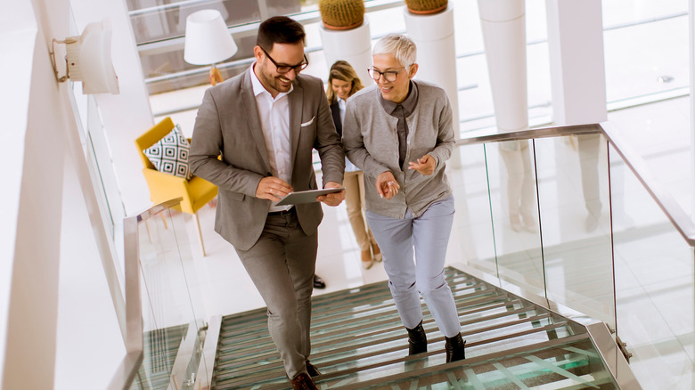 two people walking up the stairs in an office