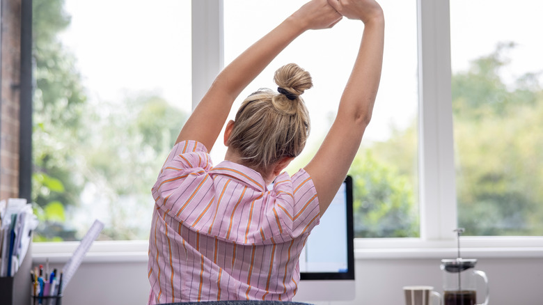 woman stretching at desk