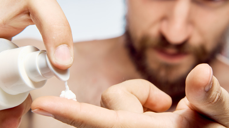 Man applying cream to finger