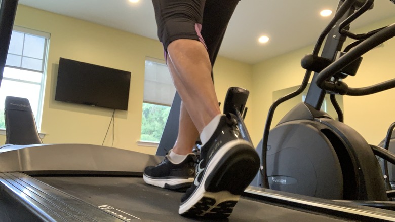 Woman's feet walking on treadmill slope