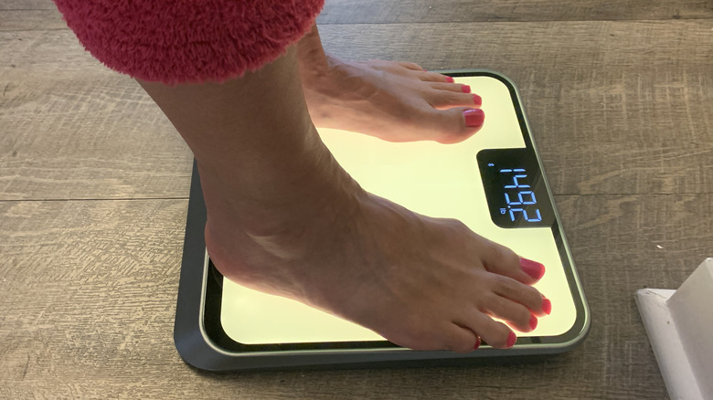 woman's bare feet on a lighted scale