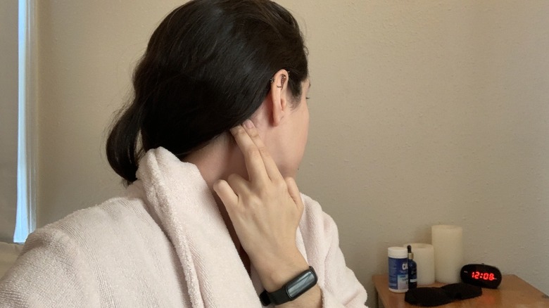 Woman massaging area behind ear