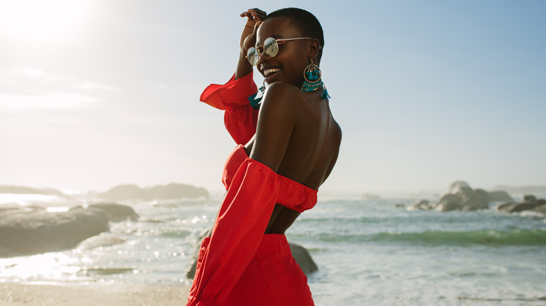 woman wearing a flowing red dress at the beach