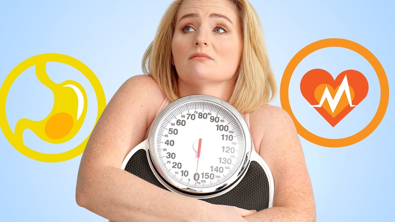 woman holding scale with stomach and heart 