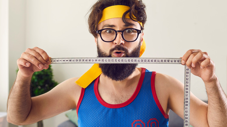 Funny man holding measuring tape