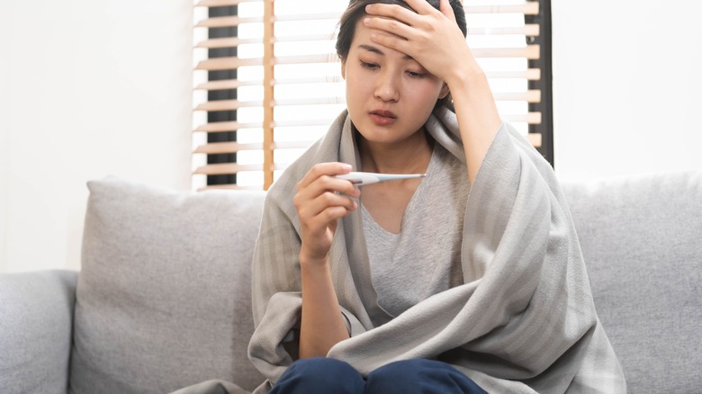 ill woman checking temperature