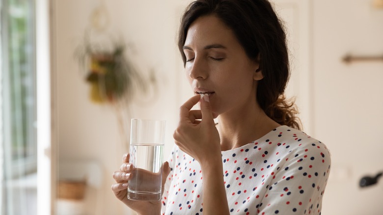 woman taking medication with water