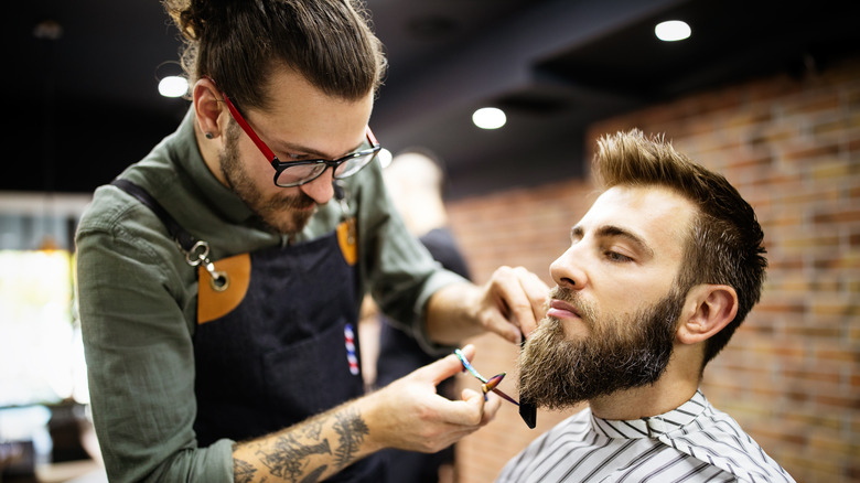 Man get beard and mustache trimmed by barber