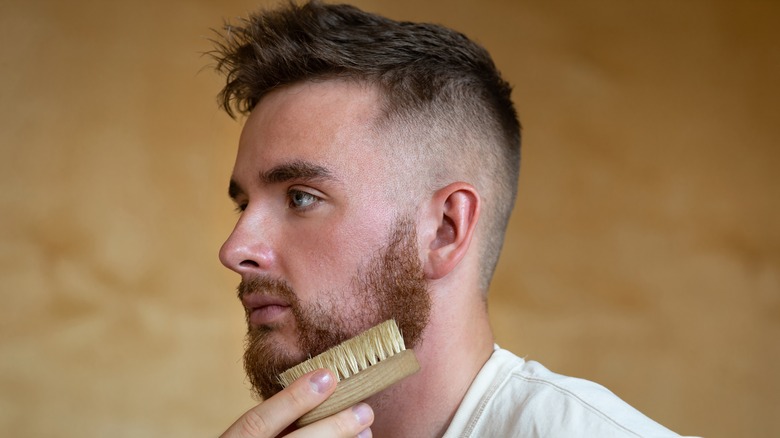 man combing beard