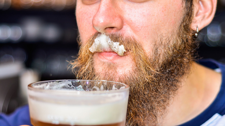 Man with mustache drinking