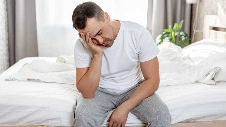 Man in bed with headache