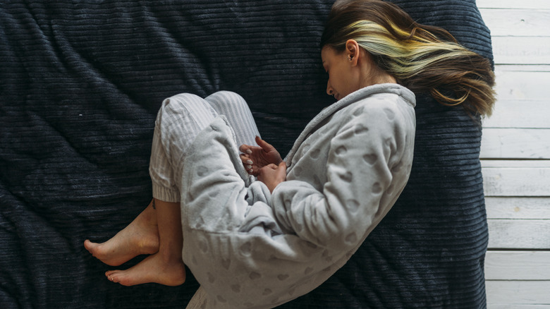 Woman lying in bed with cramps
