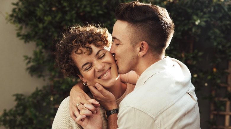 Smiling couple kissing on cheek